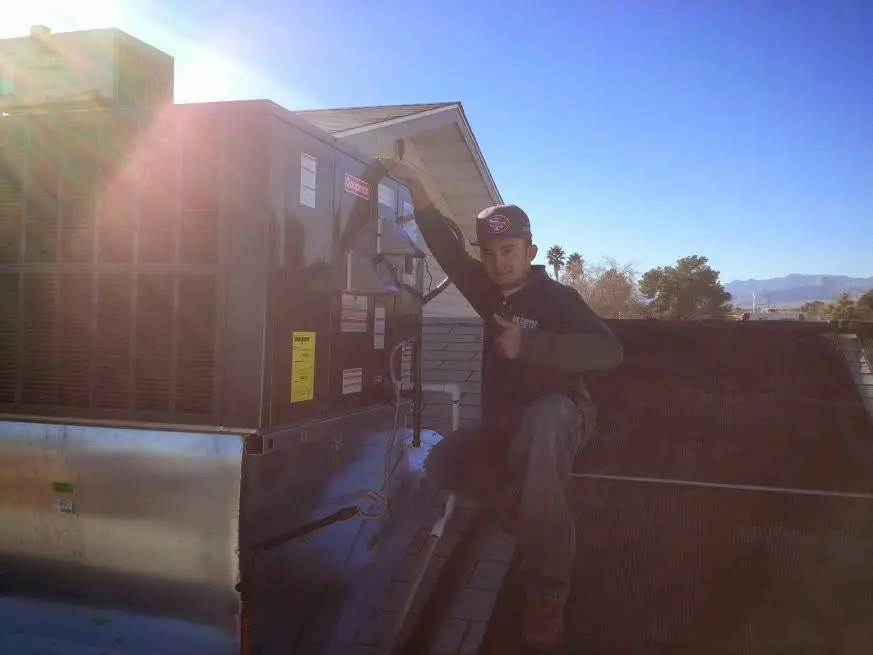HVAC technician performing Air Duct Repair on a rooftop unit in Tempe